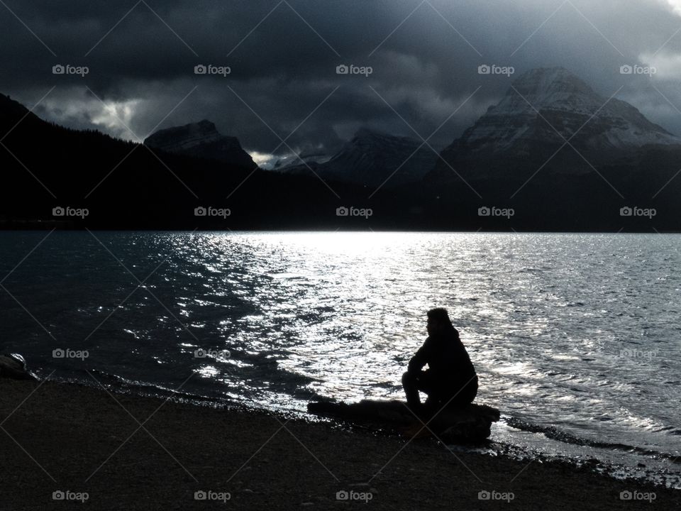 Silhouette of a guy, lake and Mountains