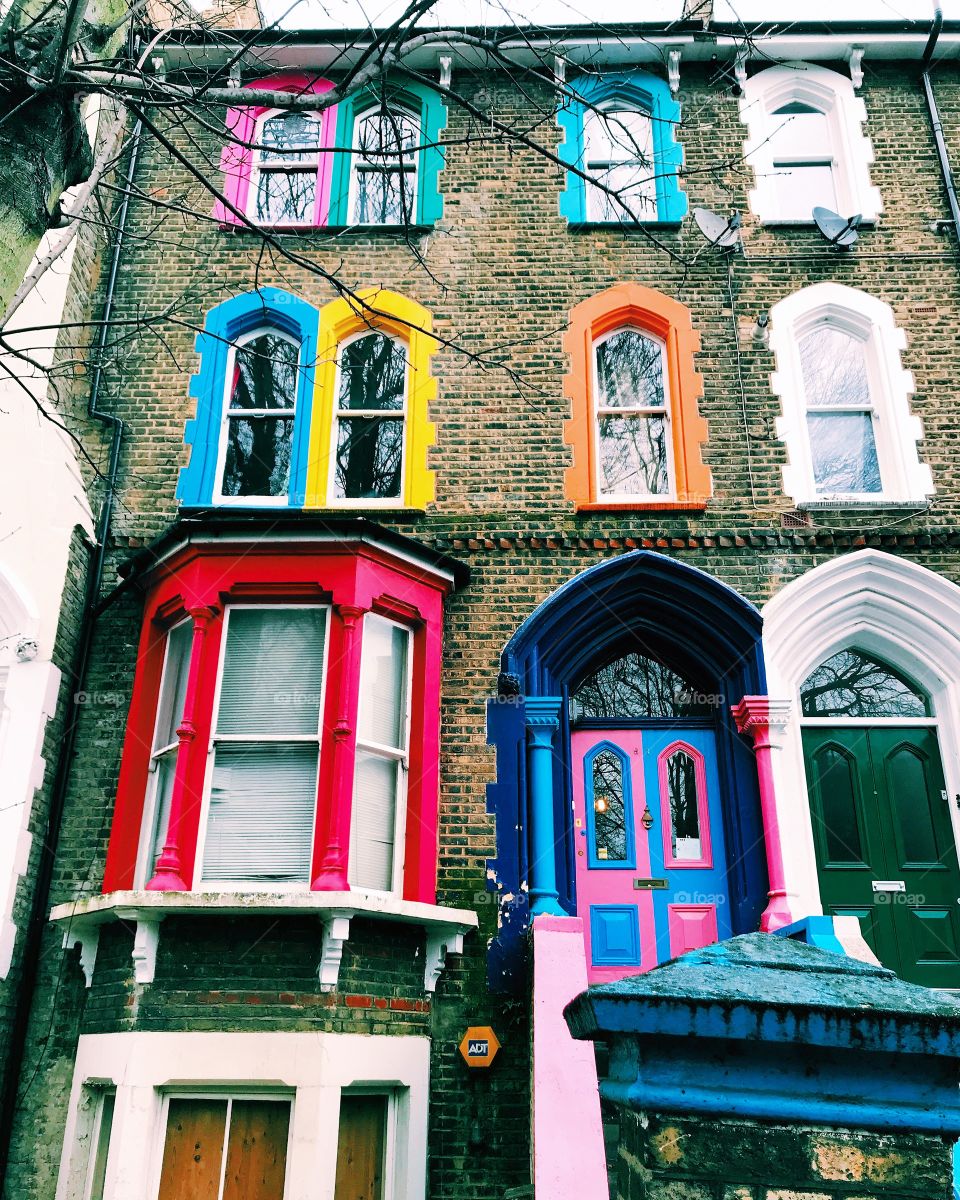 A wacky fun colourful painted house in East London contrasting other traditional properties 