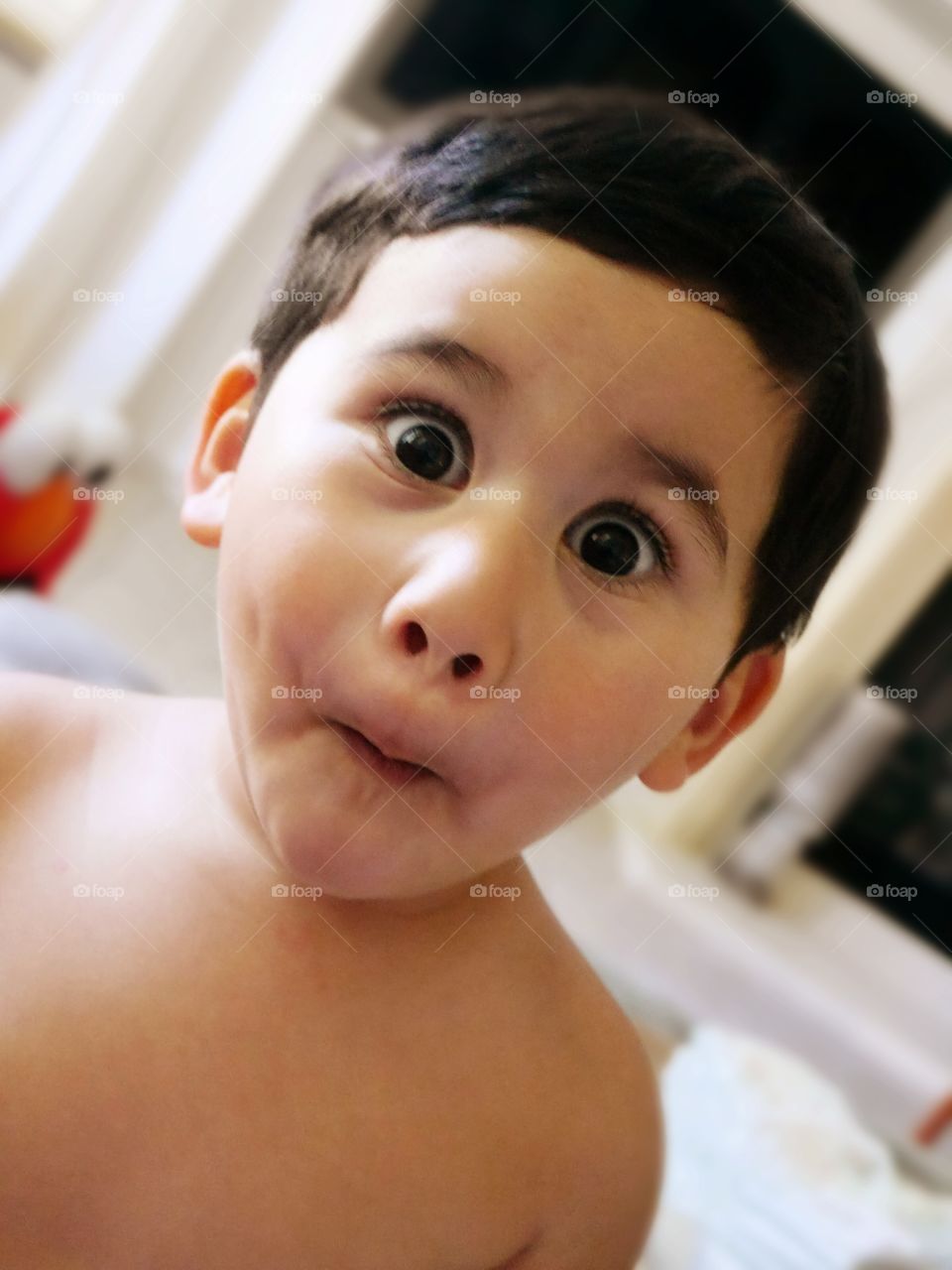 Close-up of a shirtless boy with funny expression