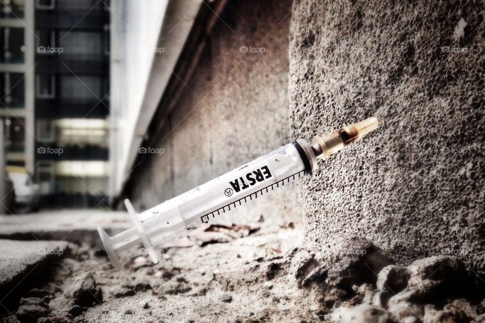 Syringe in a wall in the street