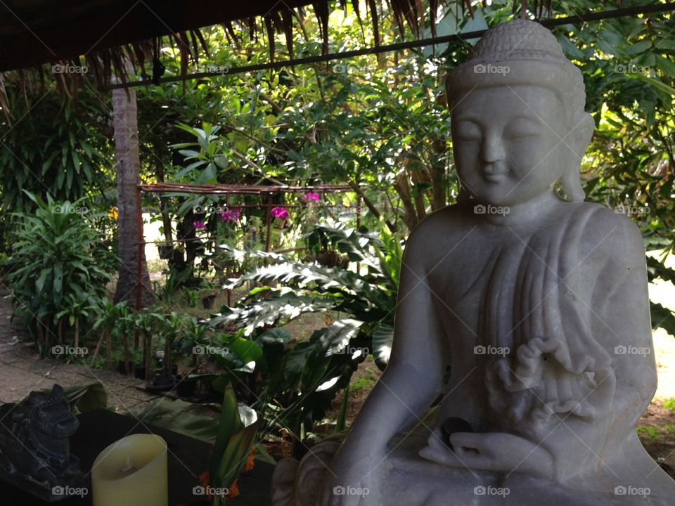 Buddha statue in the restaurant of our hotel looking in to the garden. Koh lanta, Thailand.