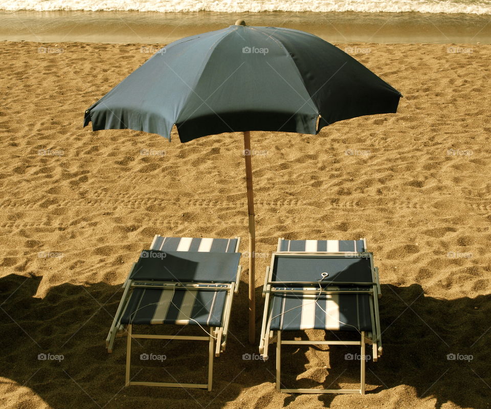 Beach umbrella and lounge chair on the beach