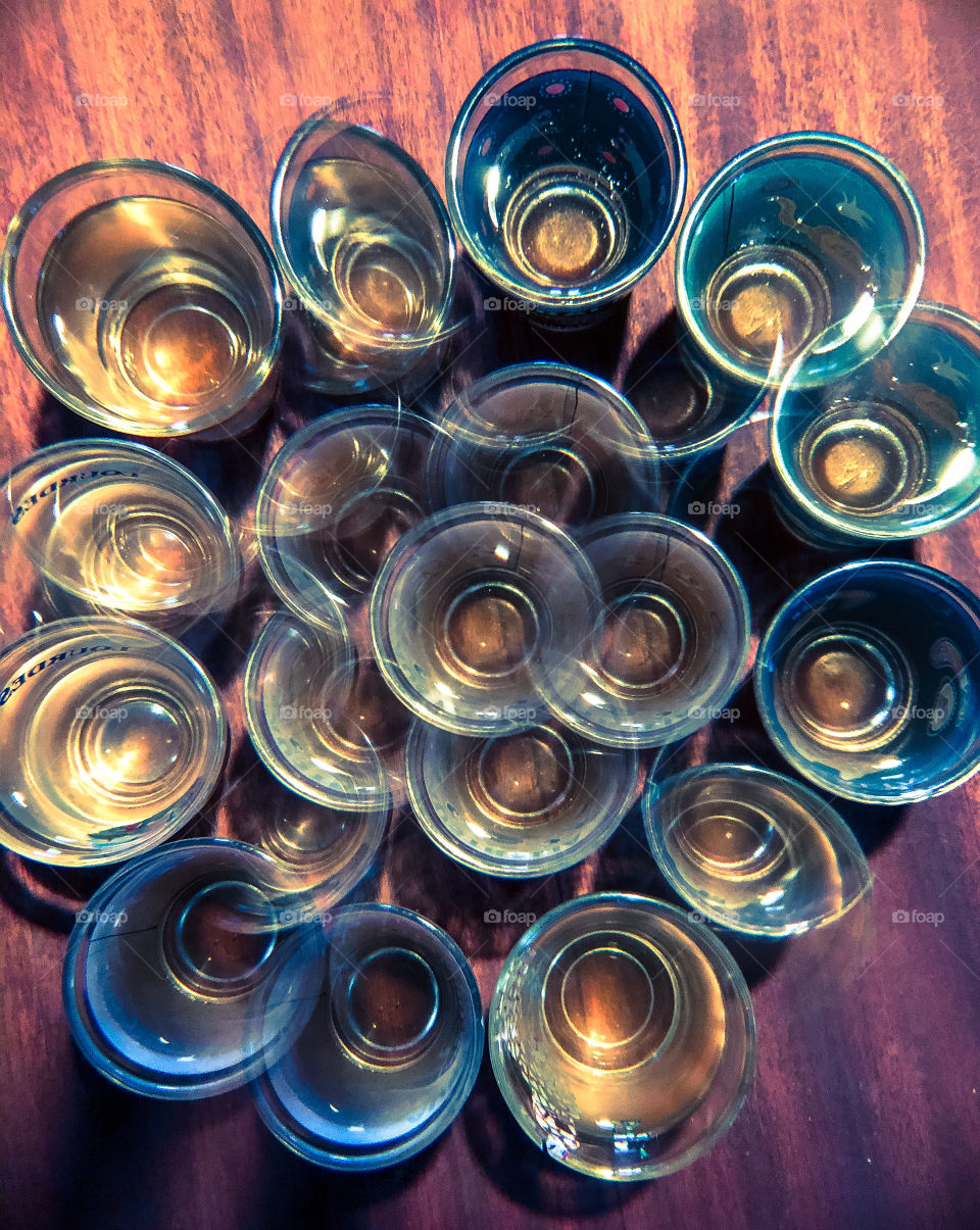 A view from up above on some shot glasses through a kaleidoscopic lens, giving the image a slightly drunken appearance 