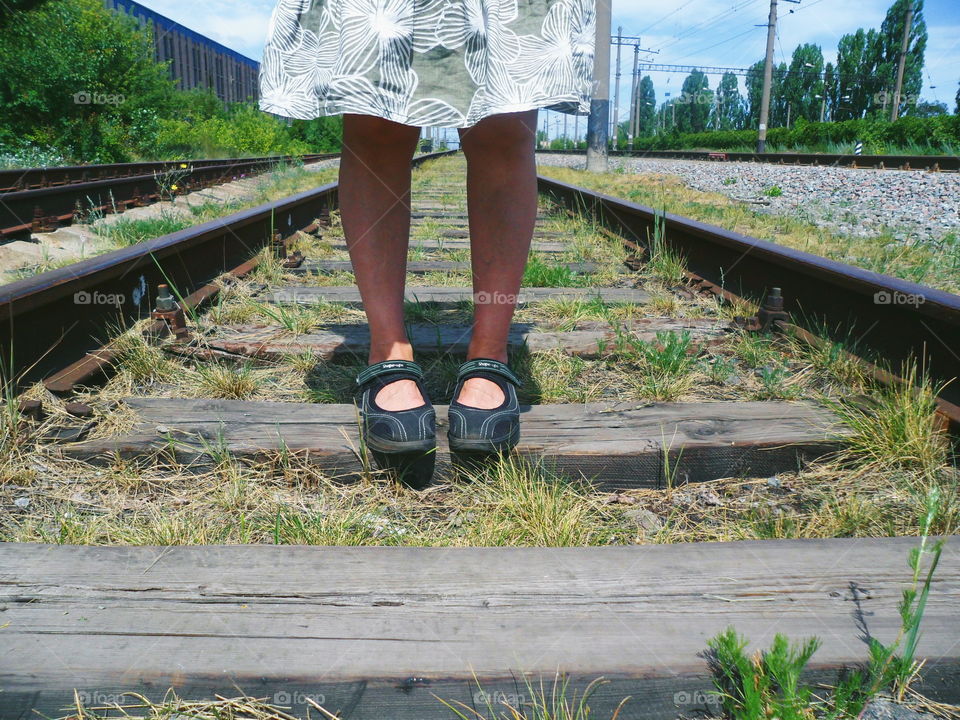 The girl is standing on the tracks