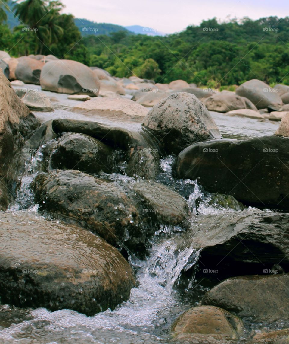 This water flows between the rock formations on the river bank which is receding because if the river floods this is not possible because all the stones will be submerged in the flooded river water.