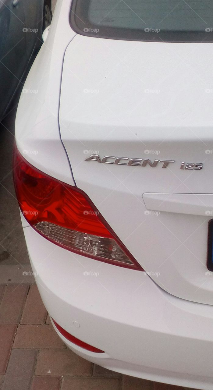 White clean modern Accent 125 car parking in street on pavement in daylight