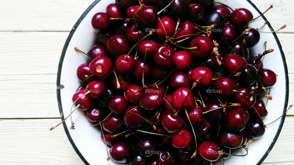 cherries in a bowl on a white background