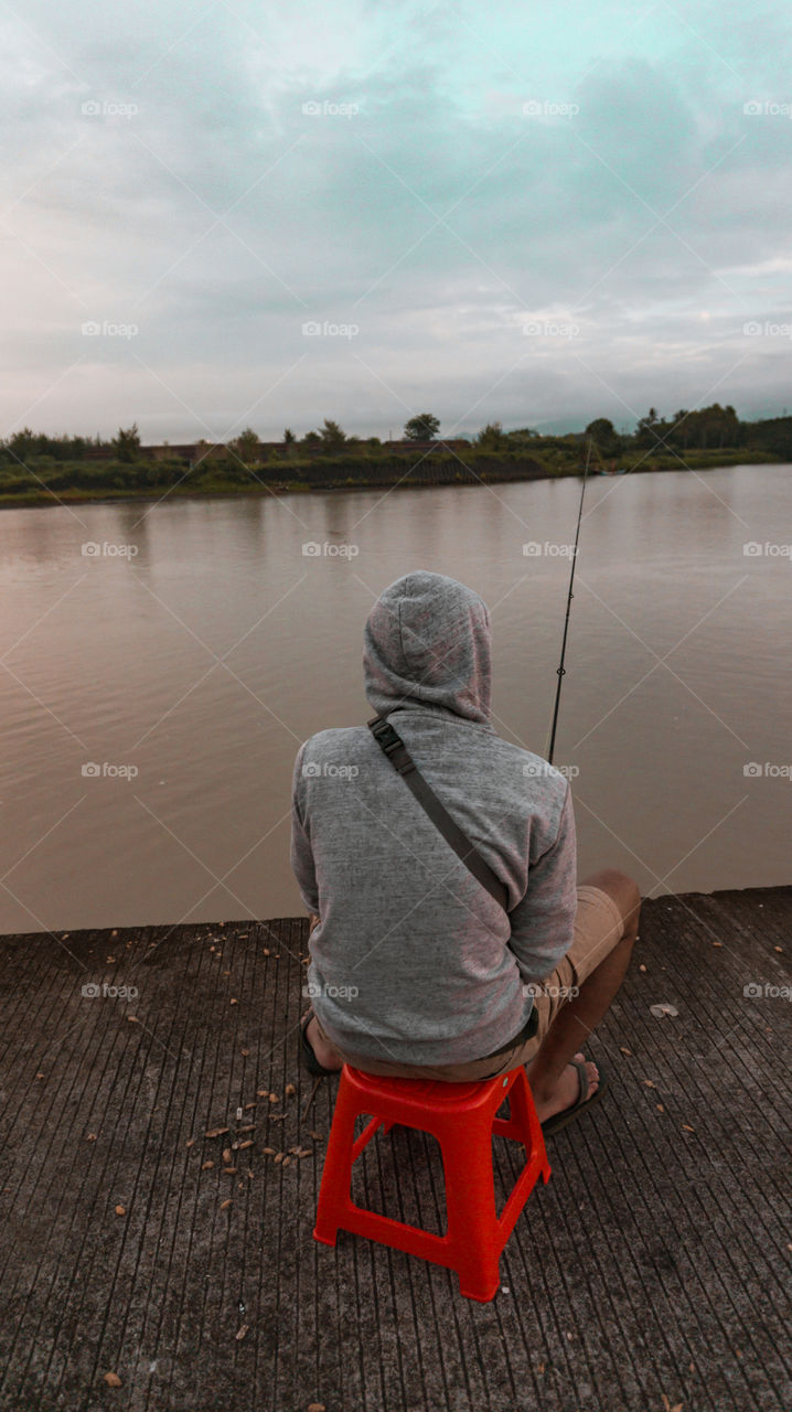 An angler is sitting by the river