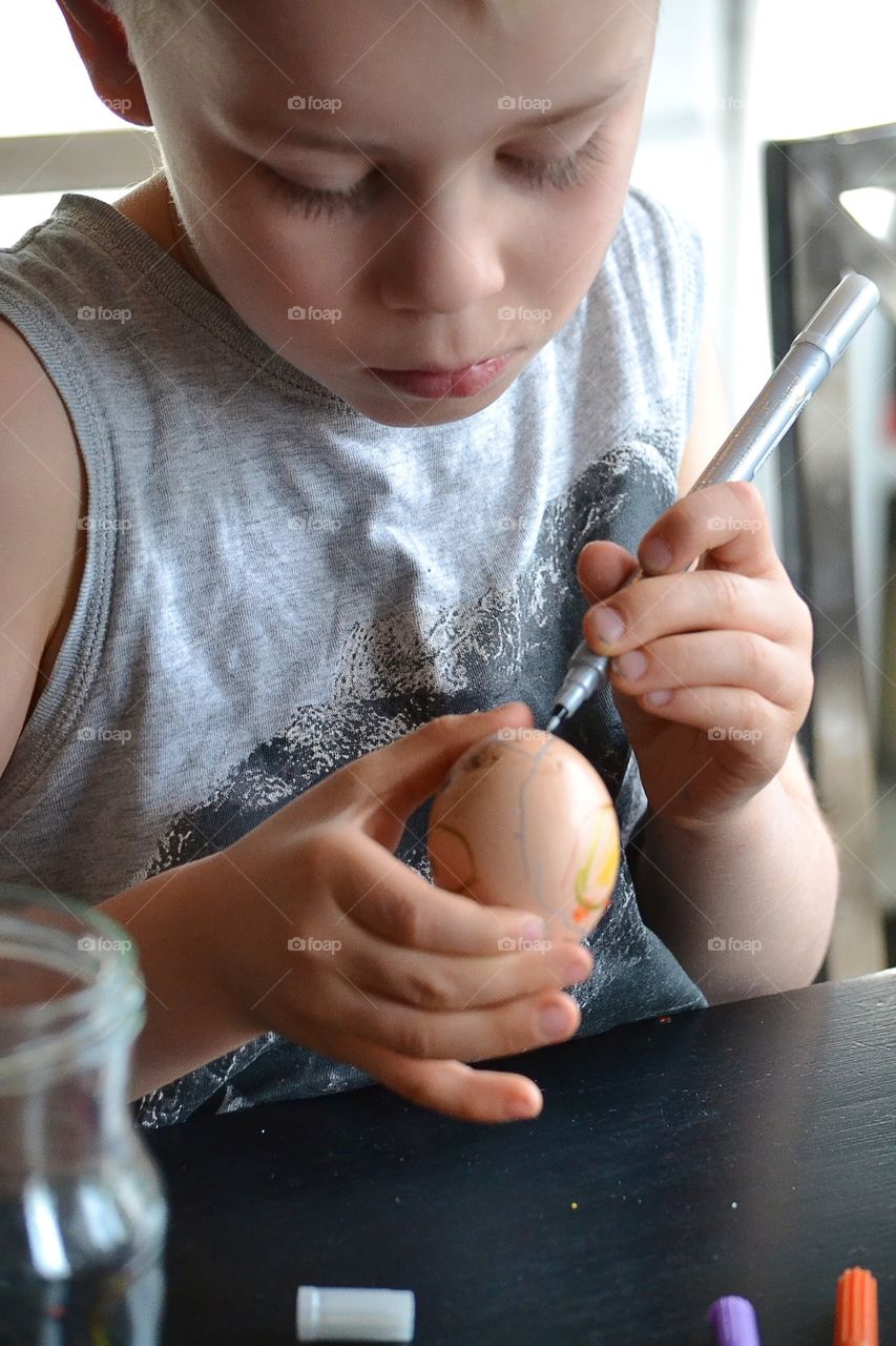 Boy painting eggs