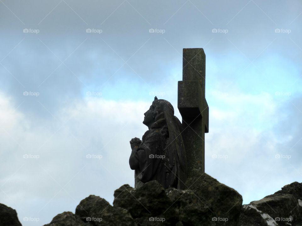 Angel statue on a cross looking towards heaven 😇