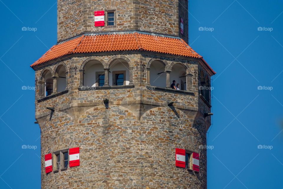 The tower of the famous Czech castle Bouzov with a typical roof and shutters.