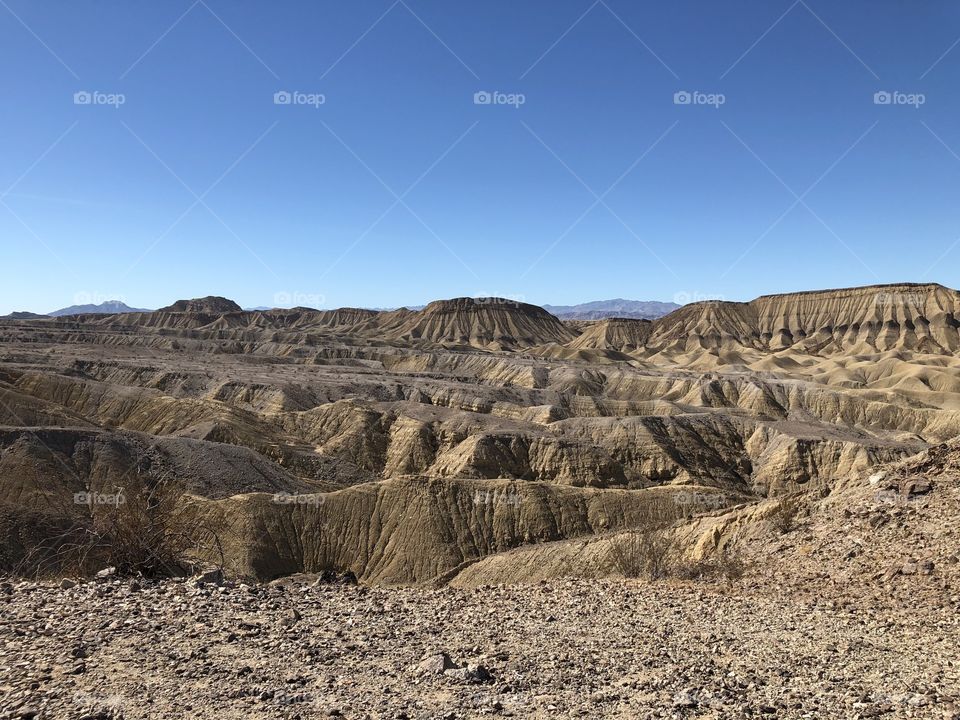 Left side of Elephant Knees Mountain in Anza Borrego Desert Park with arid  wasteland foreground hills and blue sky