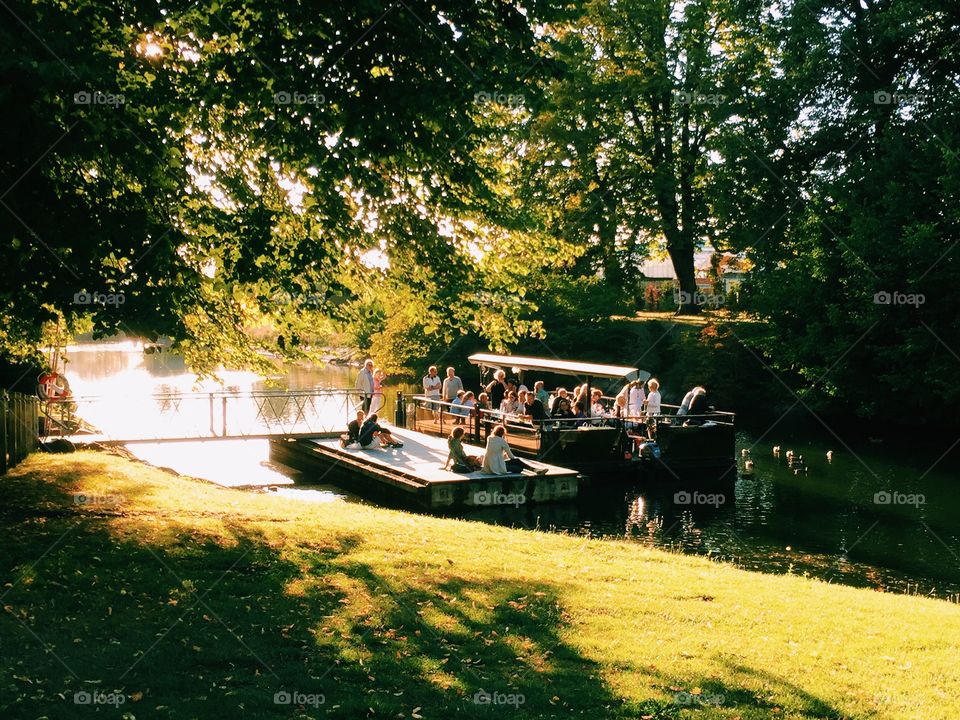 People enjoying the late sunny day together on the river in the sun 