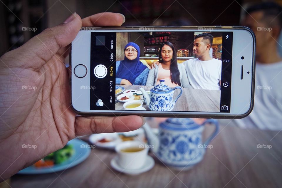 Person taking a photograph through mobile phones