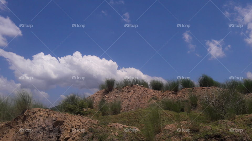 A beautiful scene of hills with cloudy sky.