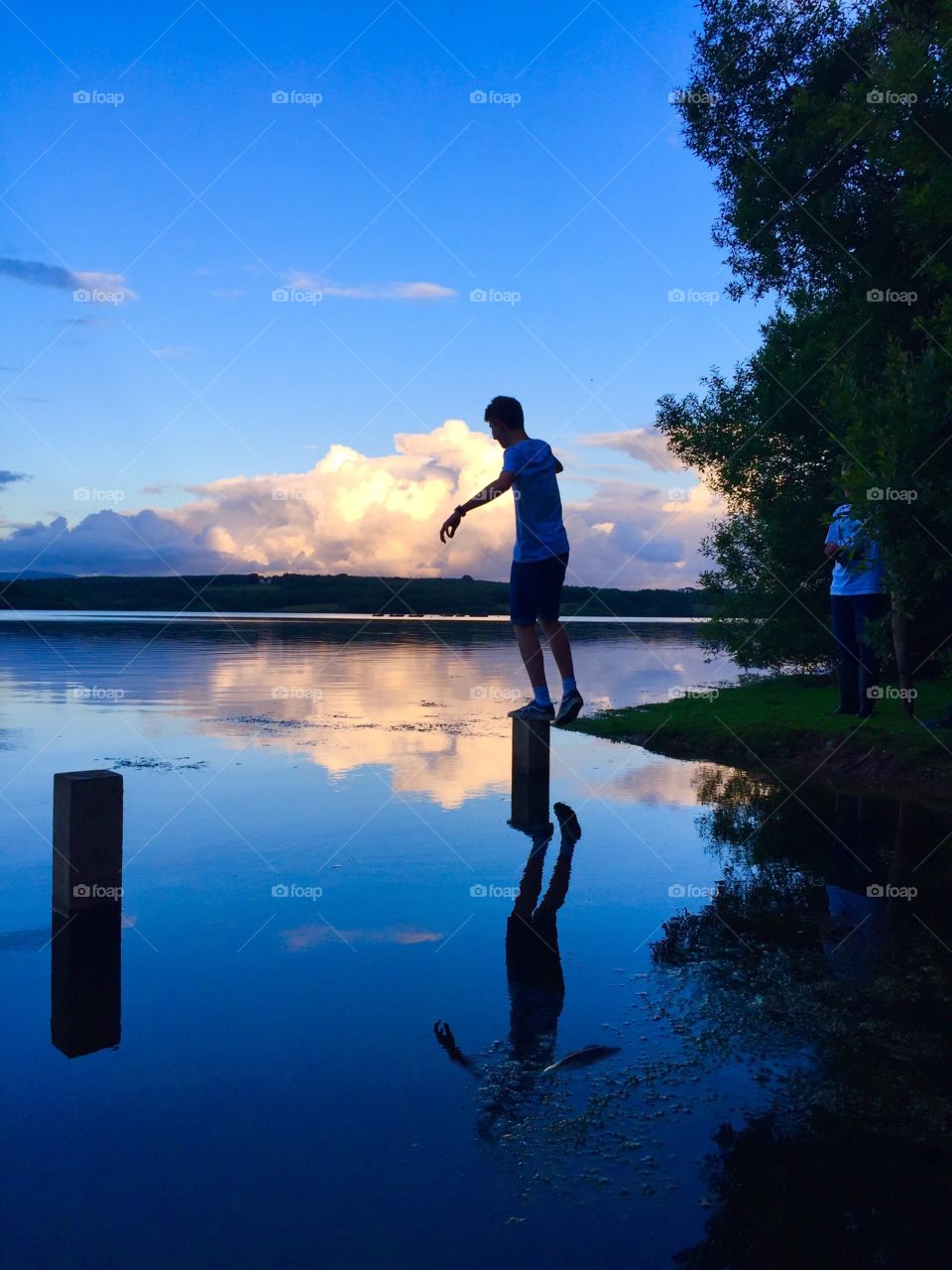 My brother balancing on a post surrounded by water at Roadford Lake.