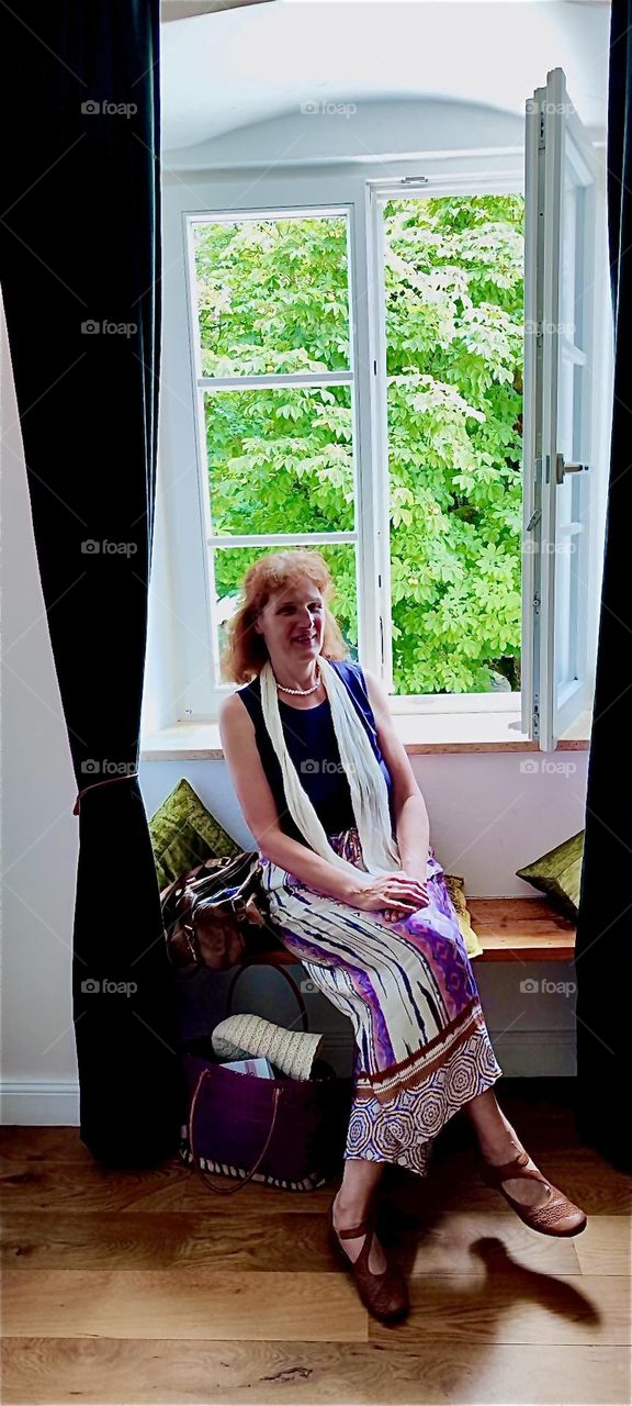 Our lady enjoys a nice balmy breeze by the window at “Schloß Blumenthal”, “Castle Blumenthal” in “Aichach”, Bavaria, a castle built in 1850 and later turned into a hotel with a gourmet restaurant and its own brewery. 2024. Hypnotic Productions