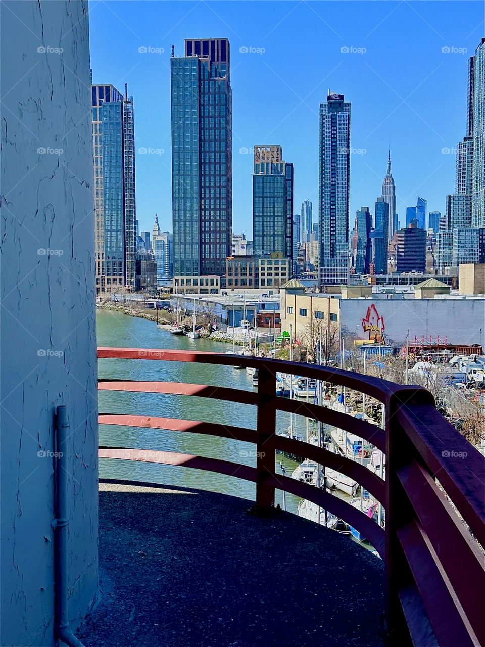 This is the central outpost of the “Pulaski Bridge” at “Newtown Creek” that connects LIC, Queens to “Greenpoint”, Brooklyn. In the distance behind LIC we see “Manhattan” incl. such landmarks as the “Empire State Bldg”. 2024. Hypnotic Productions