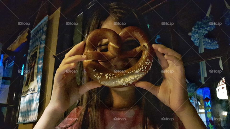 Kid playing with a pretzel in a German pub