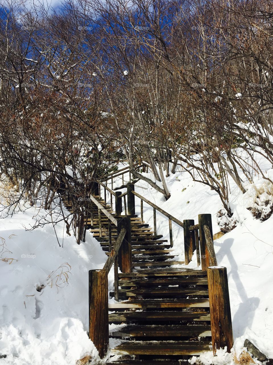 Snow mountains and wooden stair at noboribetsu, hokkaido, japan
