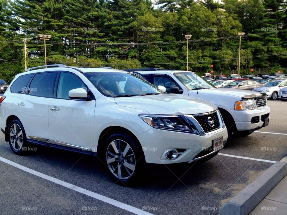 Older Ford SUV & Newer Nissan SUV
 Both are white & parked next to each other. Trading in day, buying a new car!