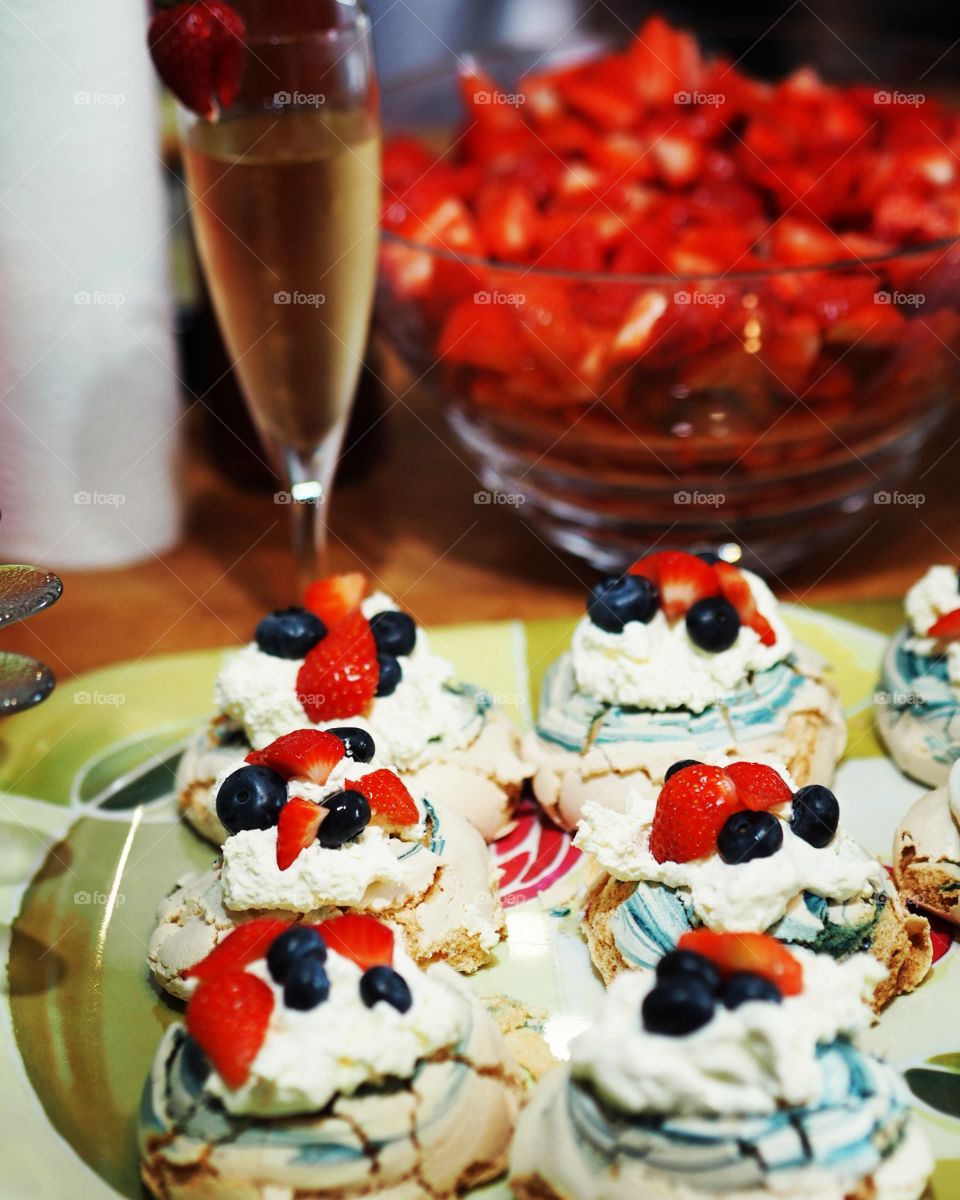 Blue swirled meringues with strawberries, blueberries, cream and champagne