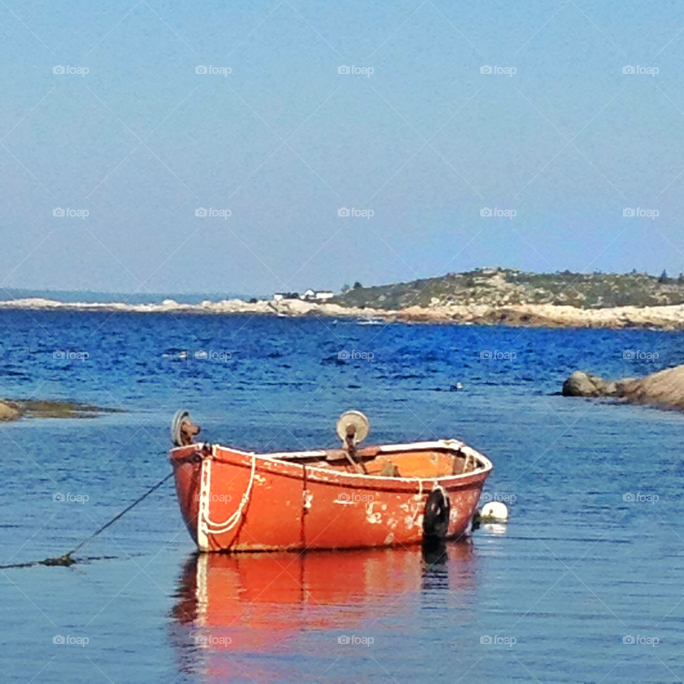 reflection of orange boat on blue water