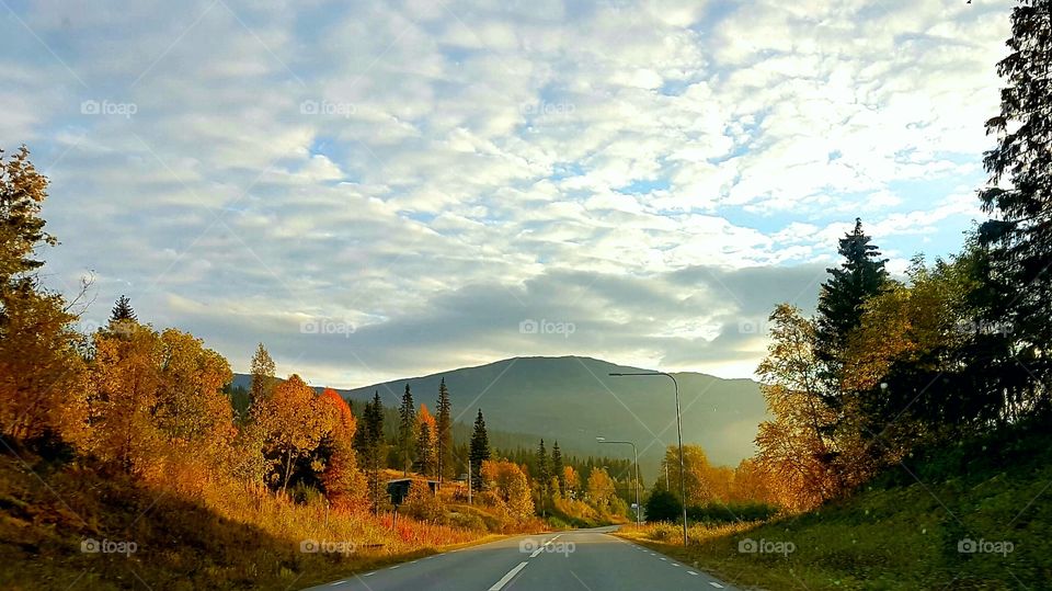 Empty road against cloudy sky