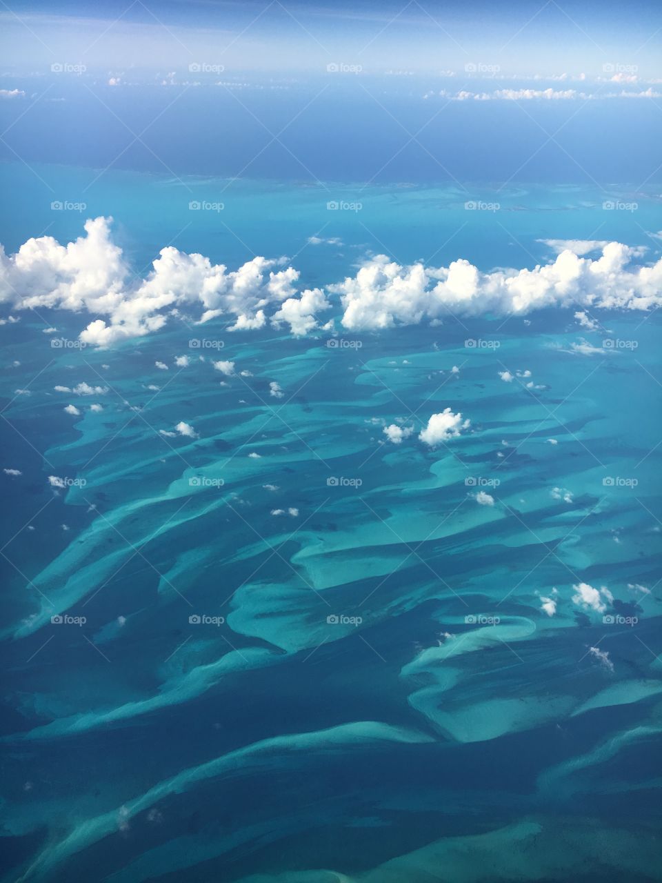 shot with an Iphone from an airplane window, beautiful reef and clear waters near the Bahamas