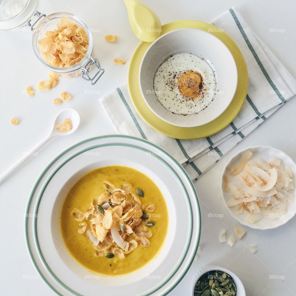 Reimagining cereal : Pumpkin soup with Kellogg's corn flakes sprinkling with coconut chips and pumpkin seeds.