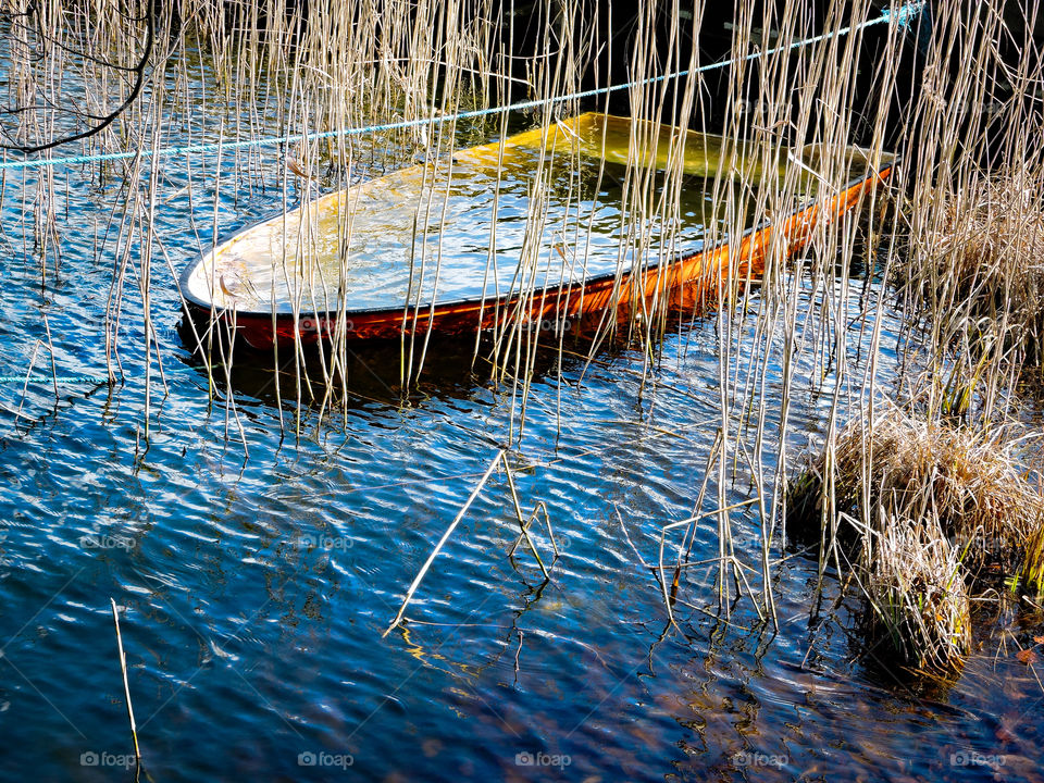 Boat filled with water in Bagsværd Lake, Denmark.