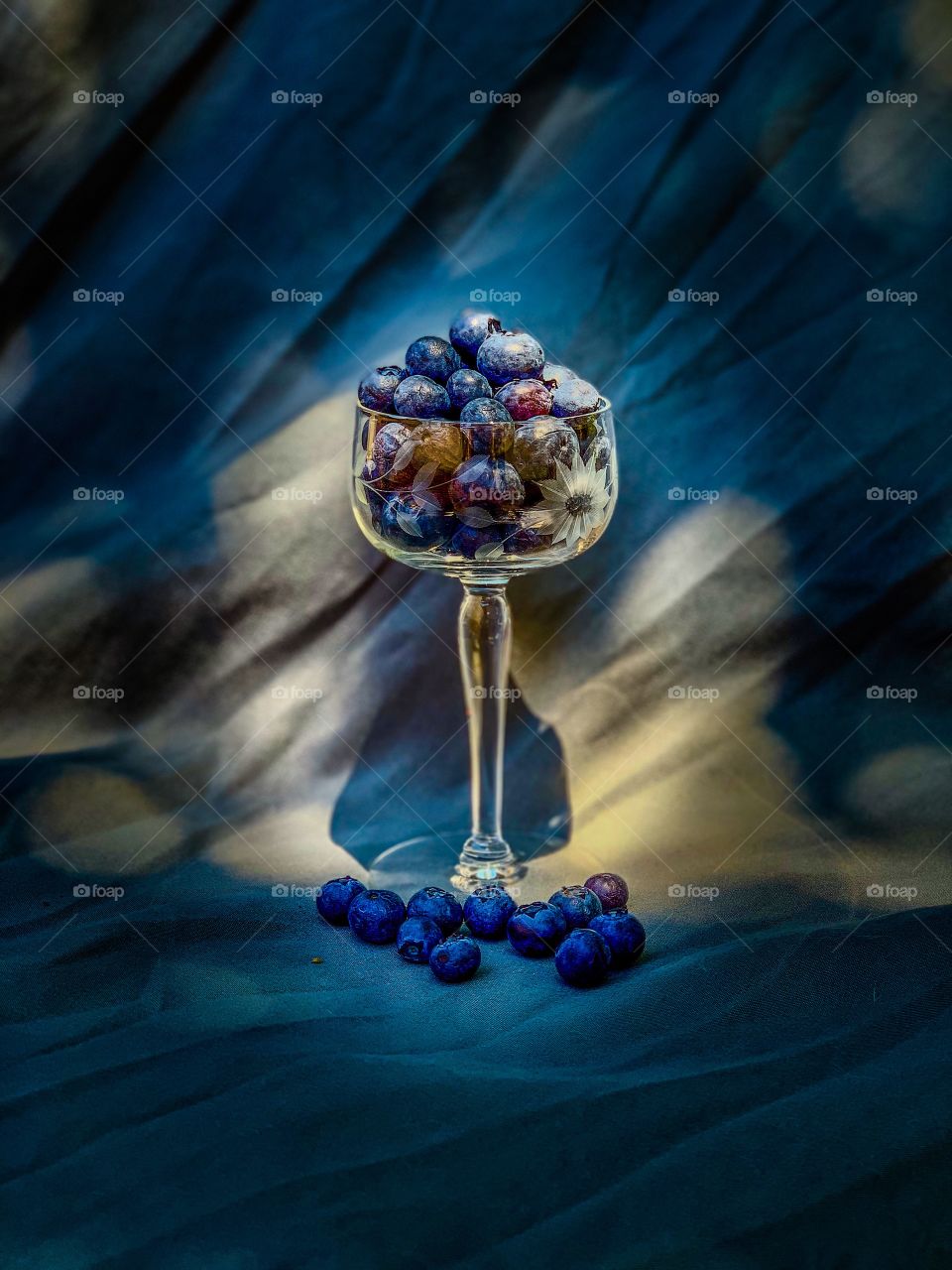 Ripe blueberries sitting in a vintage glass. They wait for a hungry person in search of something sweet.