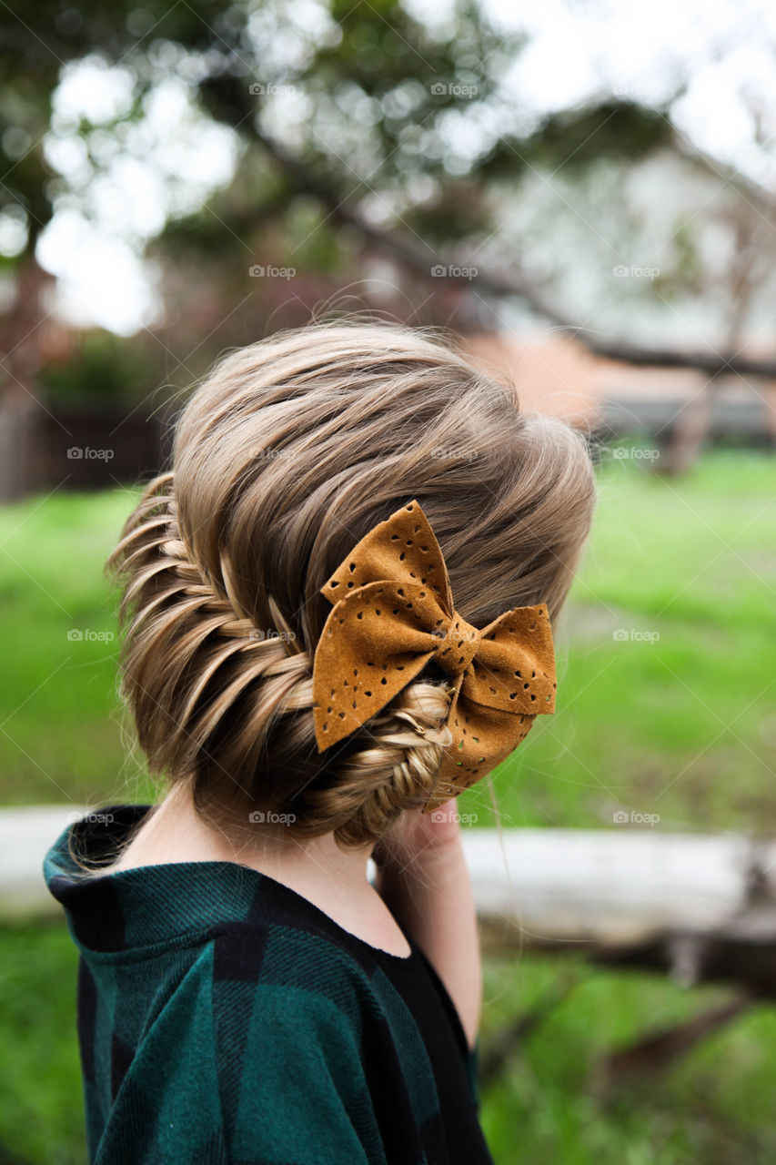 Fishtails and bows . An elegant fishtail braided Updo with a leather bow