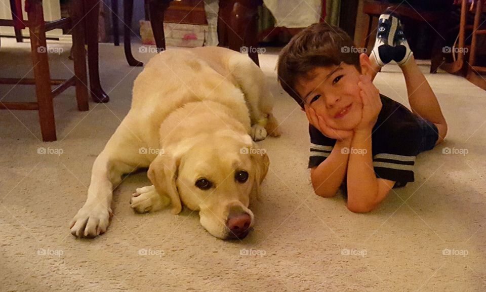 Boy and dog lying on rug