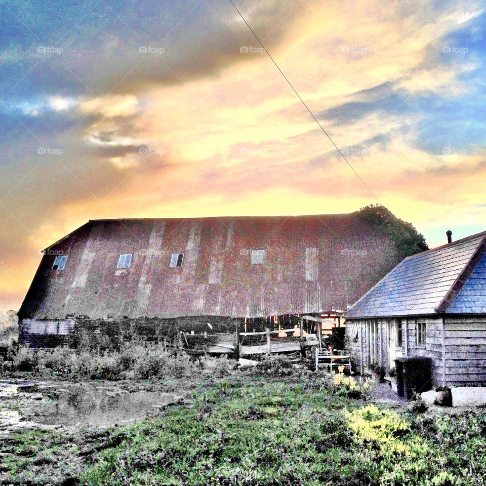 The sunset over the barn . Sun setting with an amazing sky