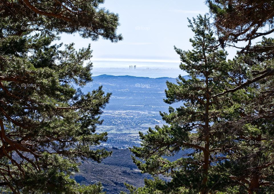 View of Buildings of Madrid showing up in the mist from the top of the hill