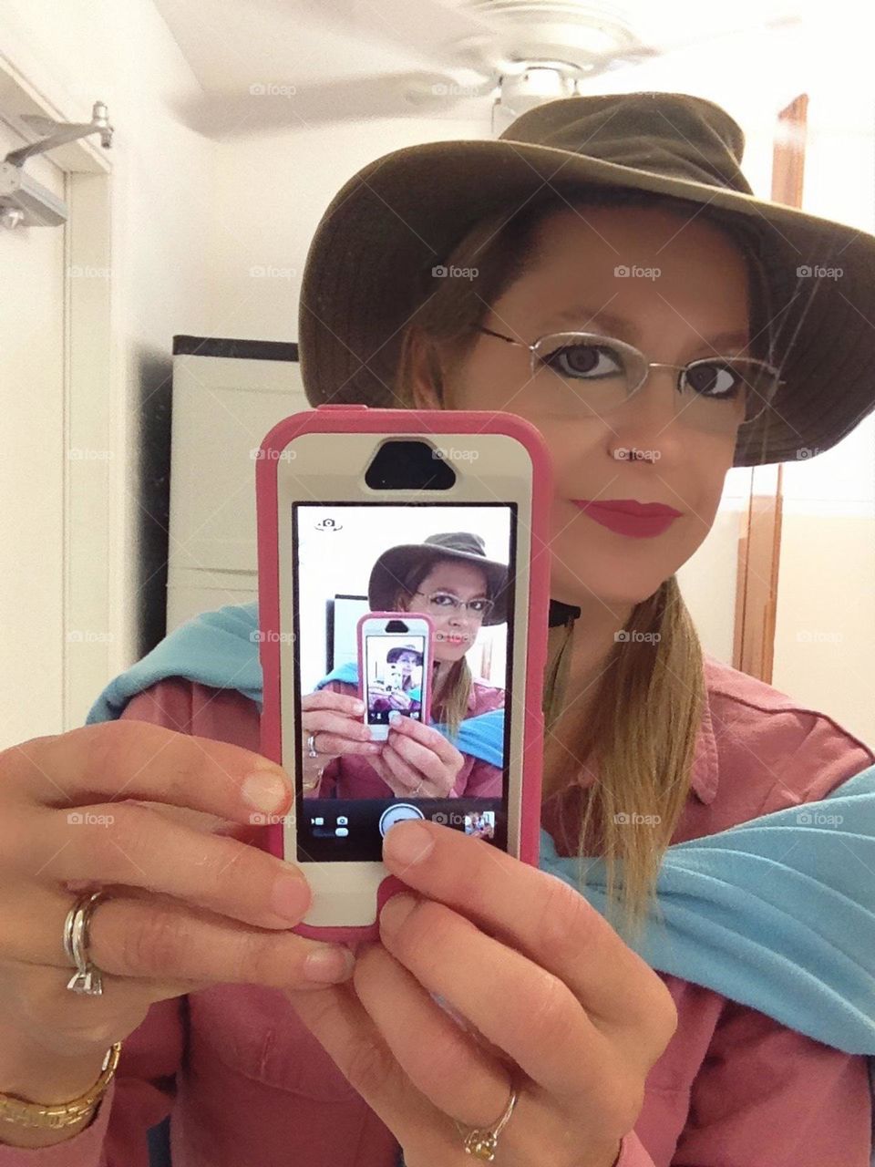 Lady in fun color clothes taking a mirror selfie.