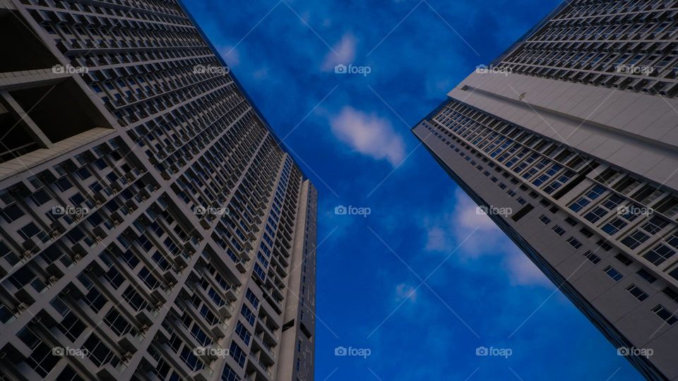 low angle of an apartment against a bright blue sky in the background