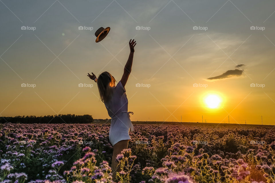 the girl in the field throws up her hat