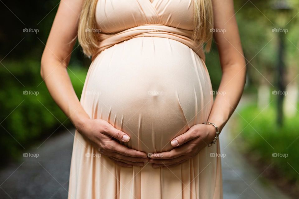 Pregnant woman touching belly 