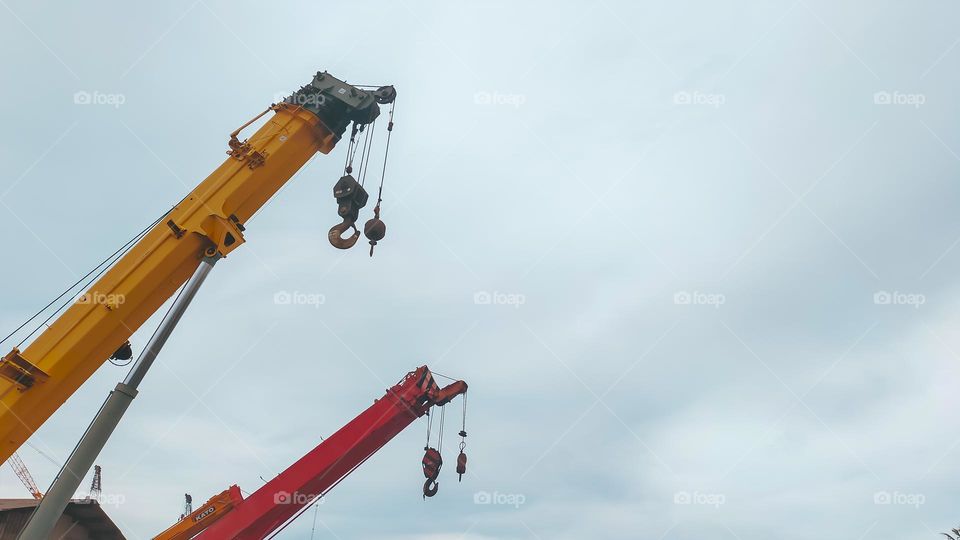 Beautiful red and yellow top boom of telescopic mobile crane with clear sky with cloud.