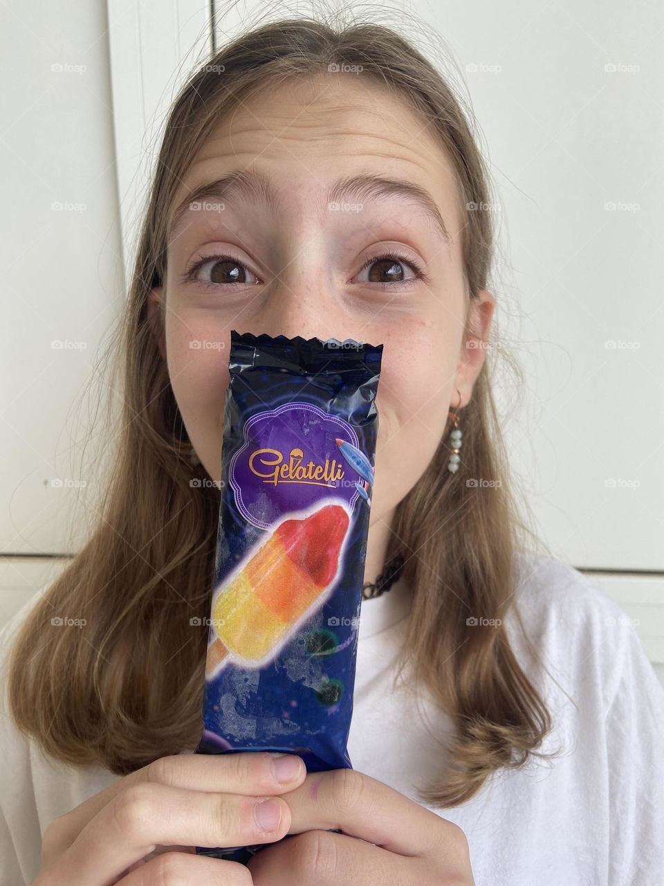 The exciting anticipation of unwrapping and eating a colorful popsicle on a hot summer day.