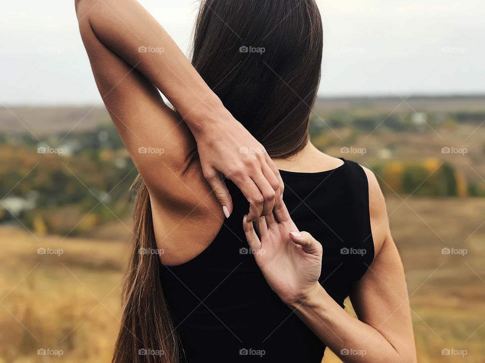 Young woman with long hair doing yoga outdoor 