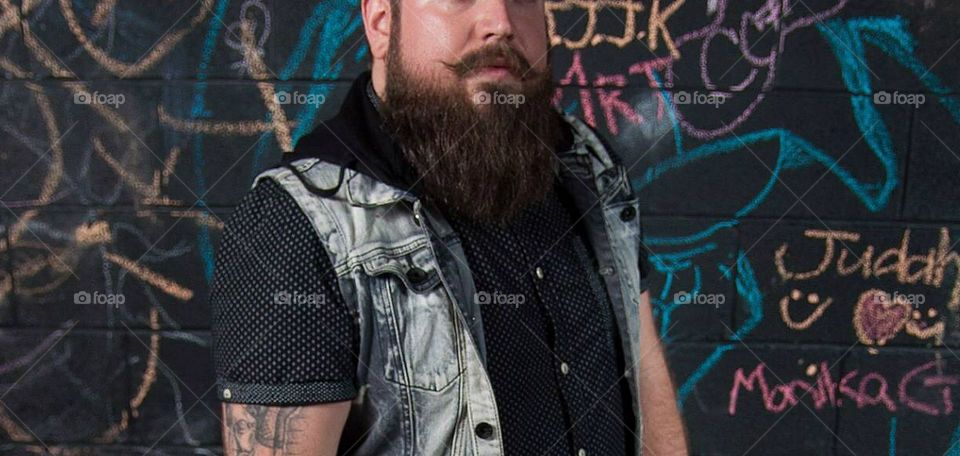 Making a statement with long beard and stylish mustache with graffiti background 