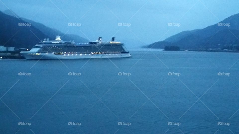 Window view from cruise ship of another cruise ship on a rainy misty evening while traveling in Alaska