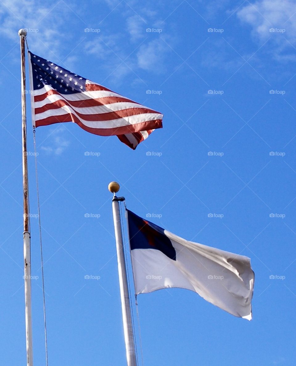 American flag flying beside a Christian flag 