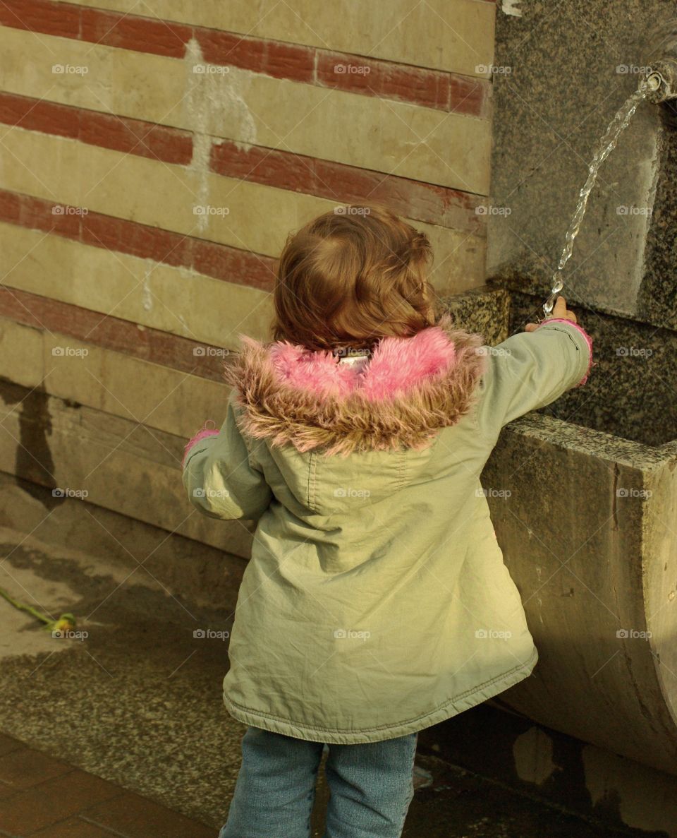 A child getting some water. 
Took this picture in Sophia, Bulgaria. 