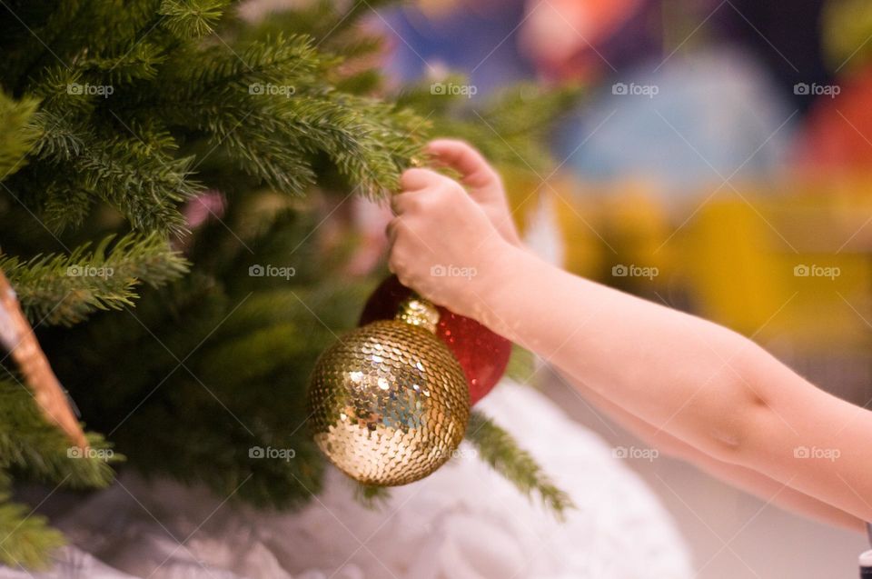 Children's hands decorate Christmas tree. Christmas background 