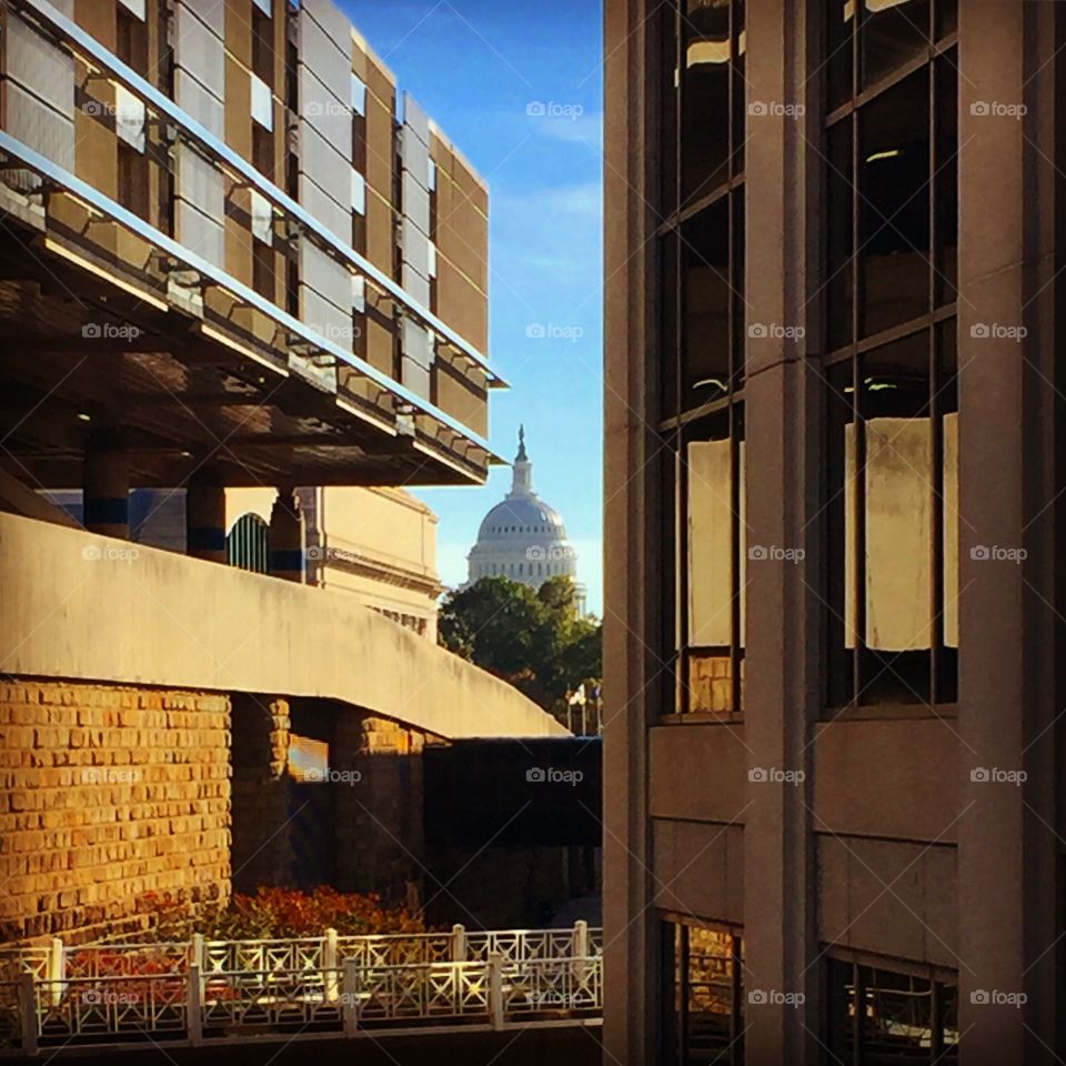The U.S. Capitol dome is seen between two buildings. (Image source: Jon Street)