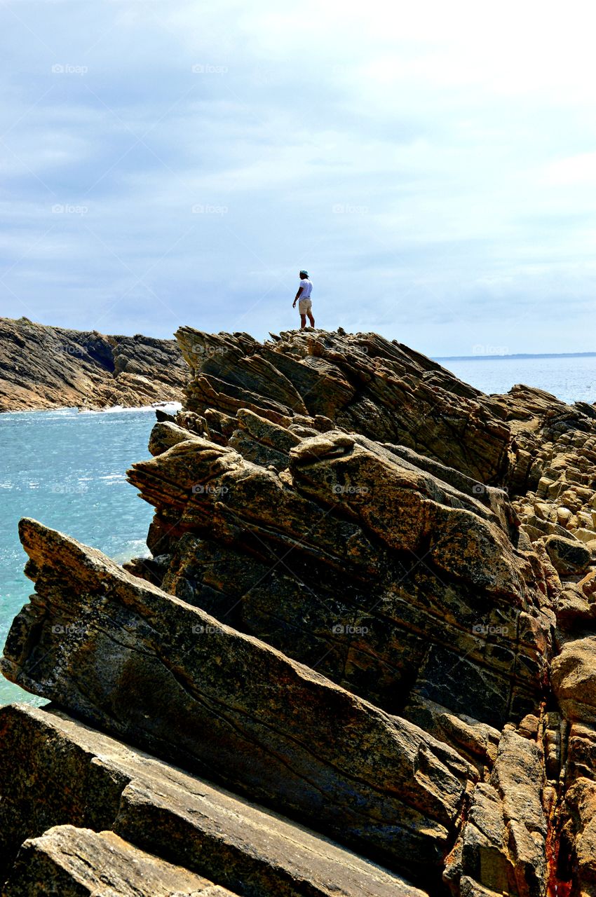 Climbing the rocks in front of the ocean